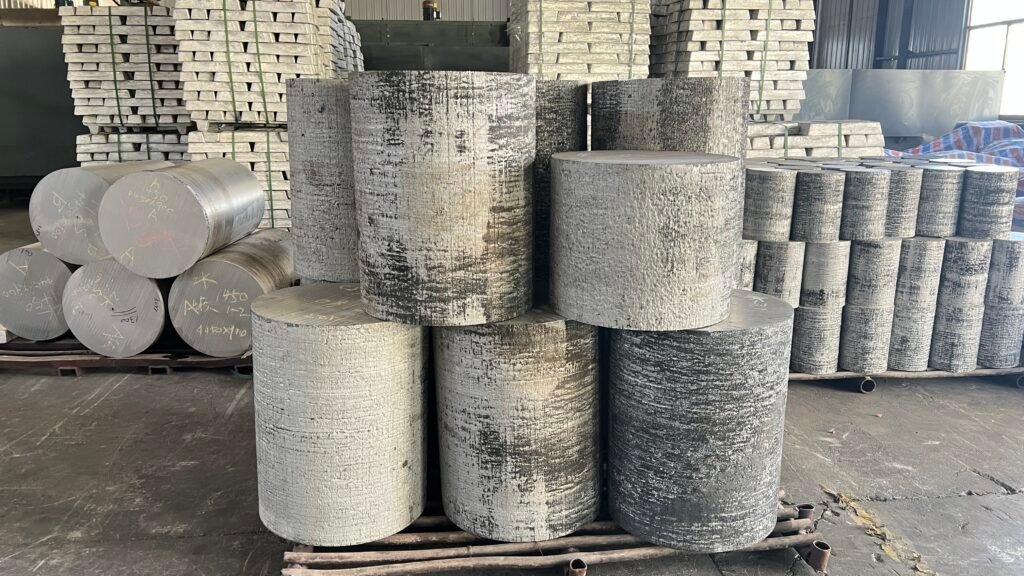 Close-up image of cut magnesium alloy billet sections prepared for forged wheel manufacturing. The cylindrical billets are cleanly sliced, showing raw metal texture, and are yet to undergo forging or machining.
