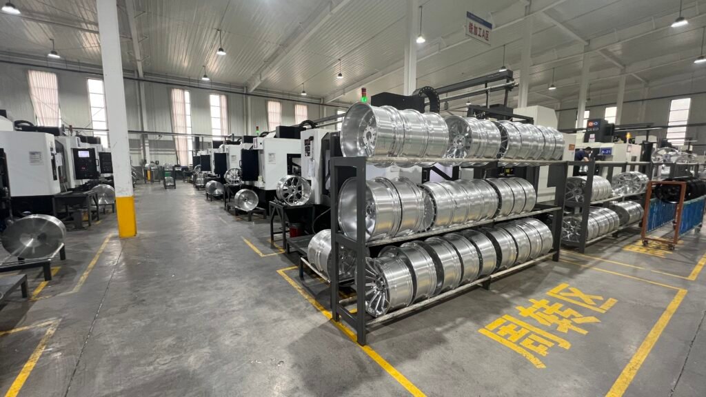 Custom forged wheels in various stages of production stored on racks inside FLEXIFORGED’s machining facility in China