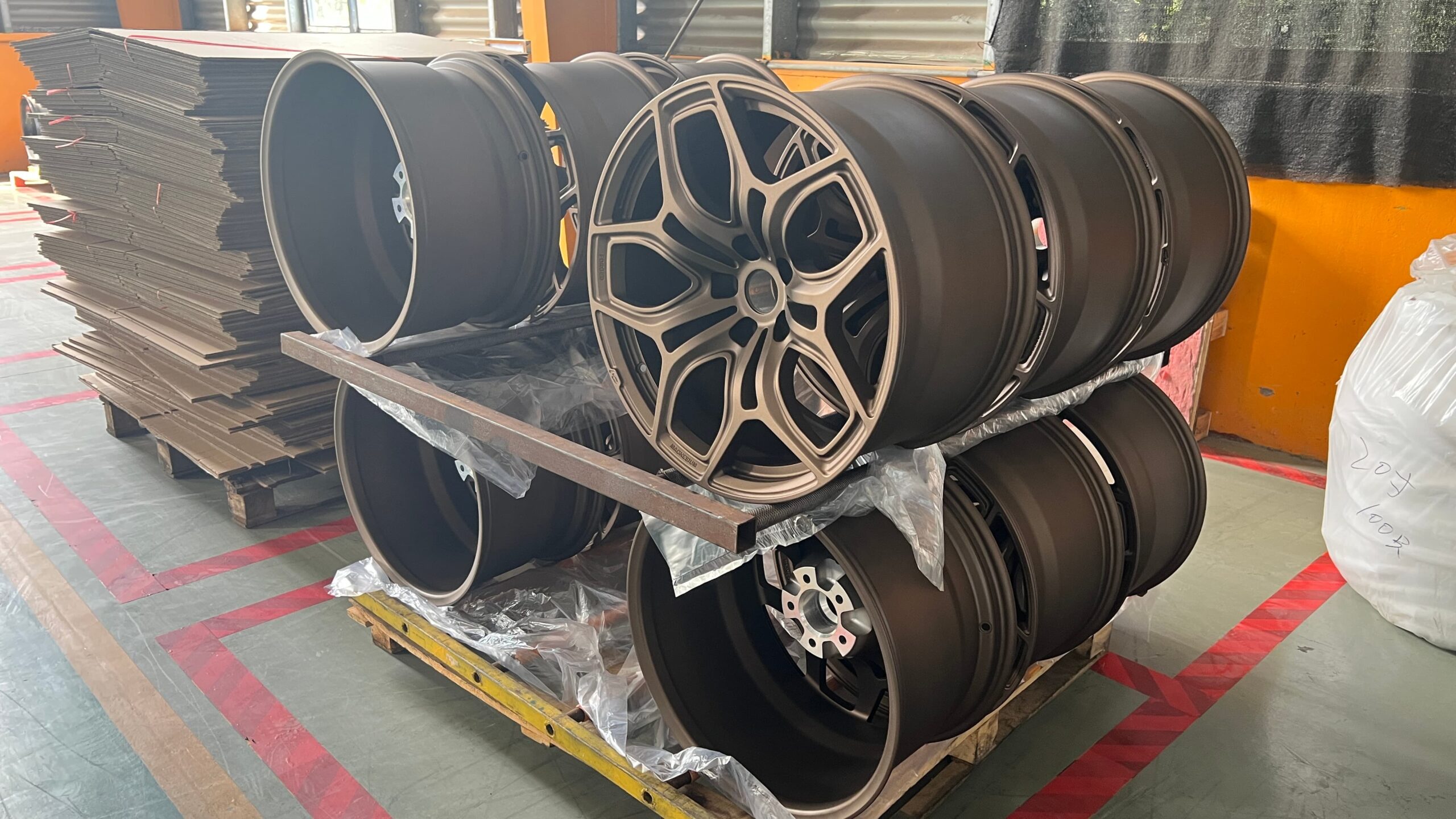 Finished forged magnesium wheels after painting, lined up for inspection and packaging at FLEXIFORGED