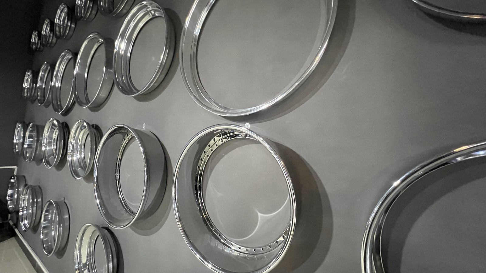 Polished wheel lips and barrels in a range of diameters and depths displayed on the showroom wall