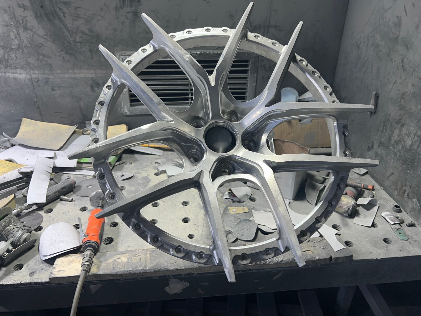 Hand surface finishing of a forged wheel before coating