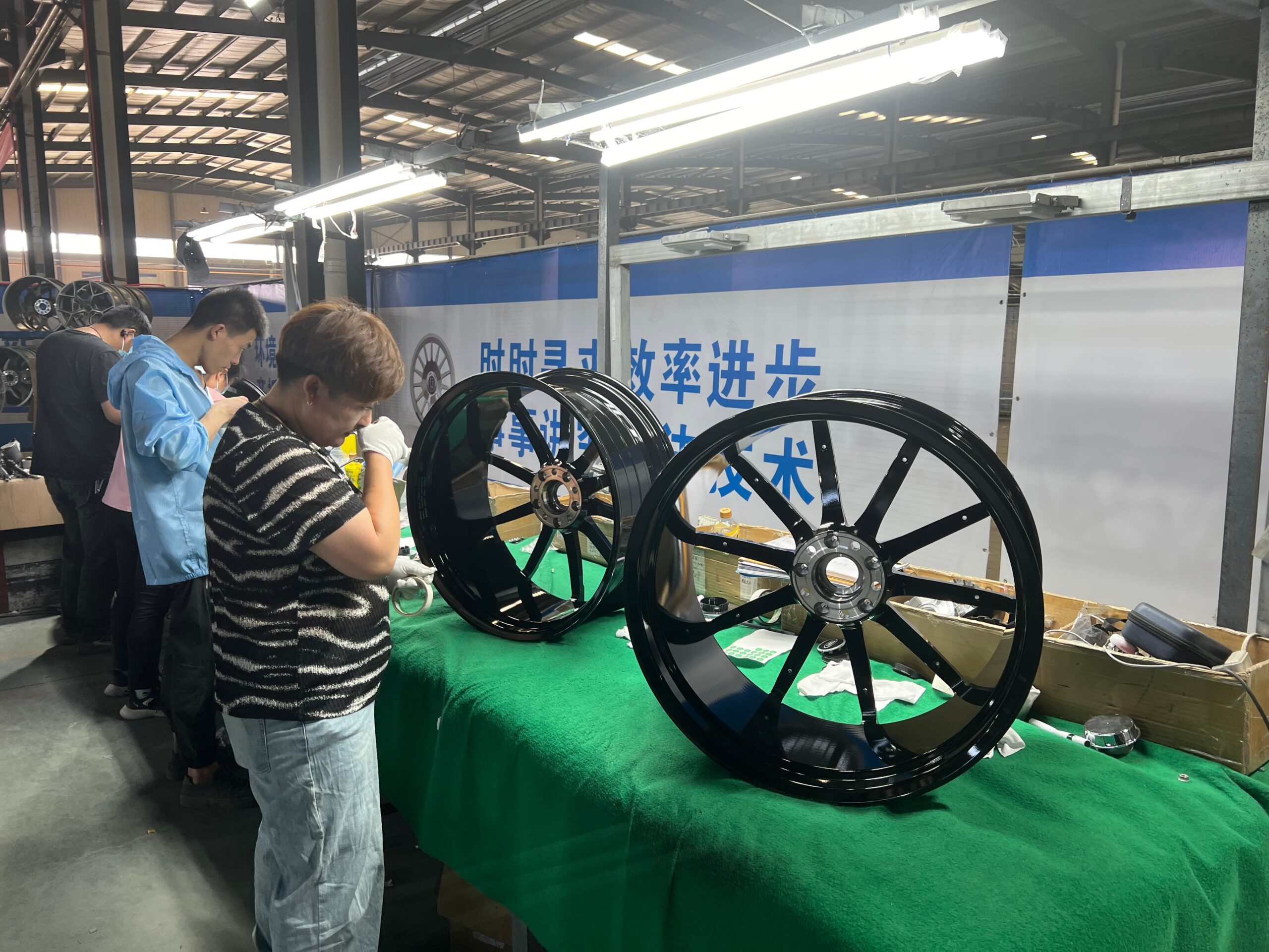 Technician measuring runout on a finished forged aluminium wheel during quality control at FLEXIFORGED forged wheel manufacturer